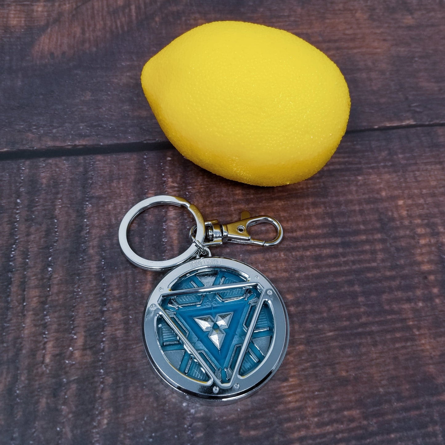 Iron Man Glow-In-The-Dark Pewter Arc Reactor Keychain. In Celebration of Tony Stark’s Iron Man as seen in the Marvel Studios Avengers films, this oversize pewter Arc Reactor glow-in-the-dark metal keychain features the Arc Reactor powering Tony’s chest and power suit in Iron Man 3. 2 inches across & nearly 1/2 inch thick! Features “Iron Man” logo on the back Includes stainless steel keyring and clip Blue Glow-in-the-Dark effect! Carry your own Proof that Tony Stark Has a Heart