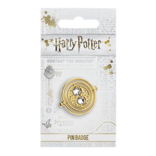 Fixed Time Turner Pin Badge Worn by Hermione Granger, the Time Turner played a huge part in the Prisoner of Azkaban. Please be aware that this fixed-pin design does not rotate. This Harry Potter Pin Badge has been created using the official style guide from Warner Bros. Pin Details: Around .75" tall and .5" wide (20mm x 16mm) Beautiful gold tone fixed-pin Time Turner with faux crystal bead detail Pin arrives on a printed Harry Potter card backer Quality metal badge pin with butterfly clutch backing